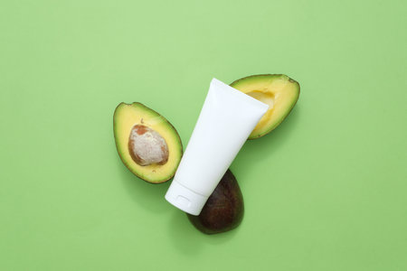 Beauty herbal skincare and haircare concept. On a green background, a plastic cosmetic tube...