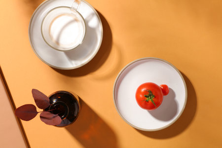 Ceramic dishes featured a cup of milk and red tomatoes. Beige background. Thanksgiving is to give thanks for the past year full of blessingsの写真素材