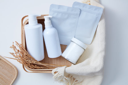 Top view of set of products for bathing, salt bath and sheet mask placed on bamboo basket with beige...