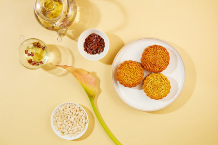 Melon seeds are contained inside a bowl, displayed with a dish of mooncakes and a dish of pumpkin...