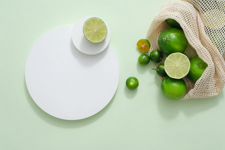 Round podiums stacked on each other arranged with a mesh bag of kumquat and lime inside. Lime and...