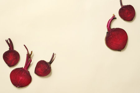 Minimal scene of fresh beetroot cut in halves decorated against beige background. Empty space to display product extracted from Beetroot (Beta vulgaris)の写真素材