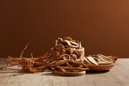 Front view of Angelica root (Angelica sinensis) and Bai Zhu (Atractylodes macrocephala) placed on wooden table. Herbs helps get more energy and treat skin diseasesの写真素材