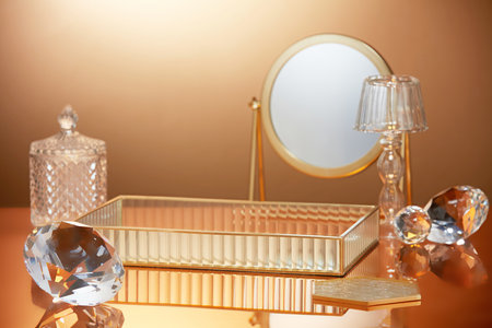 Scene to advertising and branding products with luxury concept. Diamonds, round mirror and tray decorated in backlit gold background. Space for design, display your product.の写真素材