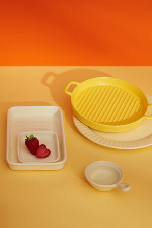 Multicolored porcelain plates decorated on color background. Abstract scene with minimalist style for product brand presentation, copy spaceの写真素材