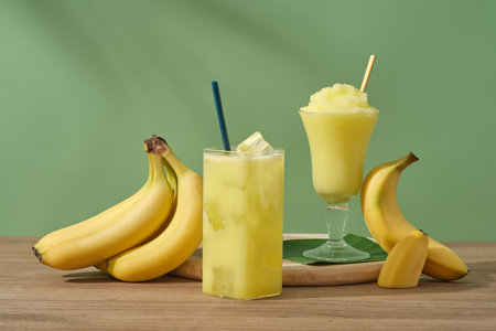 Concept for advertising product with banana ingredient. Ripe bananas and glasses of juice and banana...