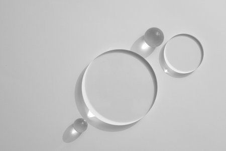 Top view, flat lay of transparent podiums and crystal ball on white background. Blank minimal design concept. Space for product presentation, advertising photo, mockup. Copy space.の写真素材