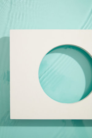 Geometric white empty podium to display cosmetic, products or goods on blue background. Top view,...