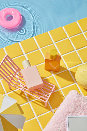 Summer vacation background concept with mini swimming float, beach chair and empty bottle of...
