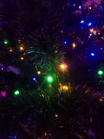Christmas background. Christmas tree and glowing garlands. Different colors. Photoの写真素材