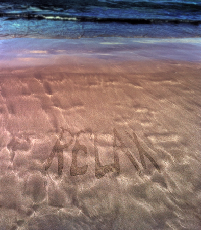 Beautiful patterns from the waves on the sand. Volcanic sand on the beach. Inscription Relax. Summerの写真素材