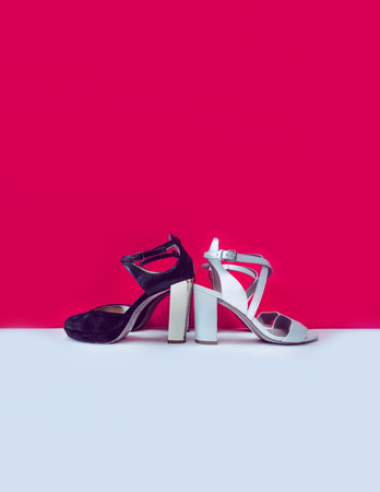 Heel shoes of different colors on a red and white background. Toned Photoの写真素材