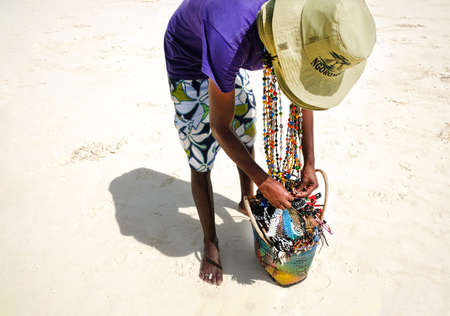 Zanzibar, Tanzania - July 14, 2018: Merchant on a beach proposes to buy accessoriesのeditorial素材