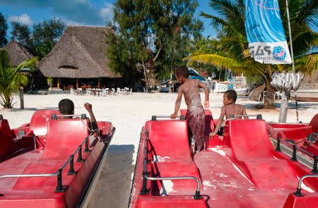 Zanzibar, Tanzania - July 13, 2018: African children play on beautiful Kendwa beach in catamaransのeditorial素材
