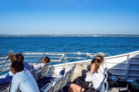 Dar es Salaam, Tanzania - July 9, 2018: People communicate in traveling time on a ferry boat with amazing ocean viewのeditorial素材