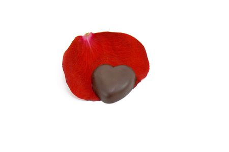 Sweetheart. Chocolate Valentine heart on the red rose petalの写真素材
