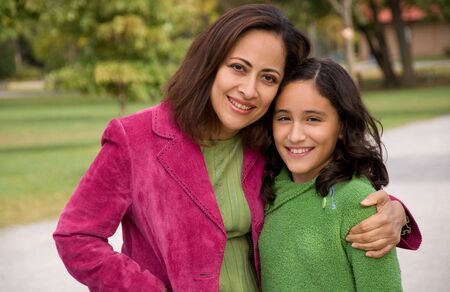 Mother and daughter hugging and looking at the camera.の写真素材