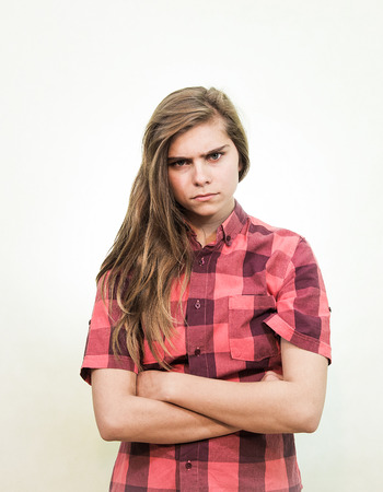 Angry teenager girl is looking into the camera with a piercing gaze.の写真素材