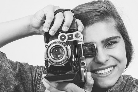 Teenager girl with an old folding camera portrait.の写真素材