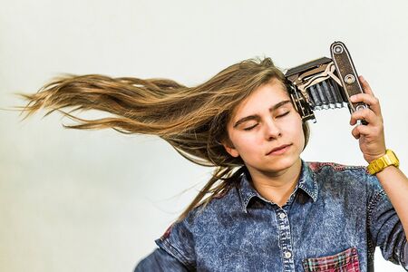 Teenager girl shooting at herself with an old folding camera.の写真素材