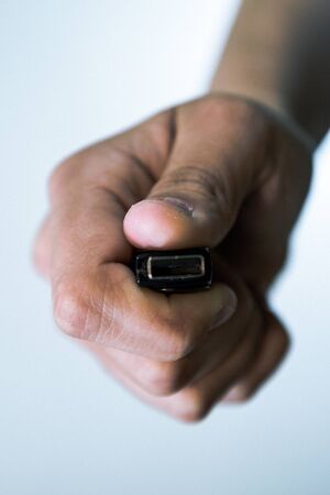 Girl is holding USB memory stick in her left hand. Futuristic lights in the foreground are visible.の写真素材