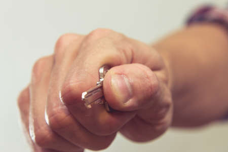 Male hand is holding a silver key to the house.