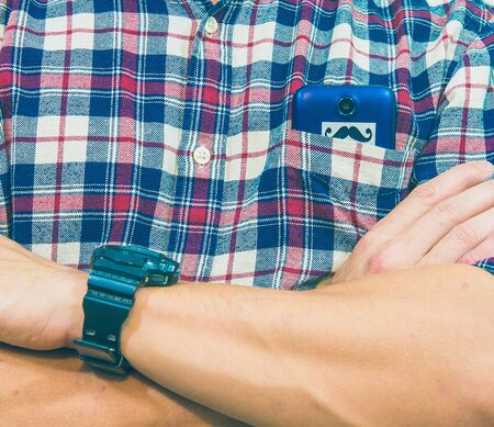 Close up shot of a guy in a shirt with a watch and a phone.