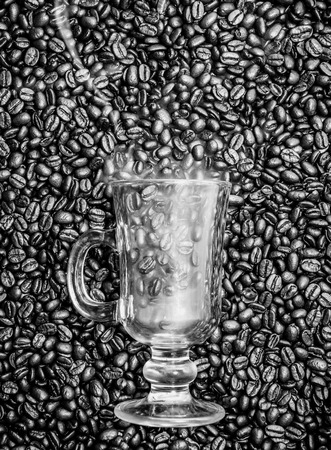 Irish coffee glass stuck in fresh coffee beans. Smoke is coming out of the glass.の写真素材