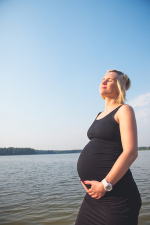 Portrait of a young and beautiful pregnant woman on the beach.の写真素材