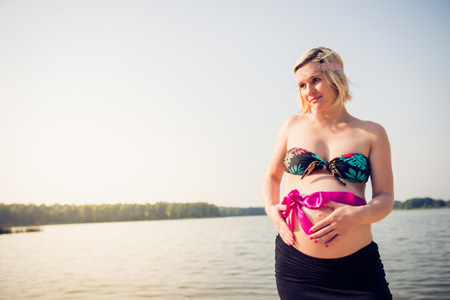 Portrait of a young and beautiful pregnant woman on the beach.の写真素材
