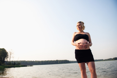 Portrait of a young and beautiful pregnant woman on the beach.の写真素材
