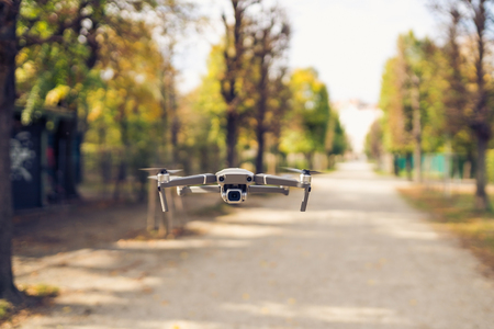 Drone flying in the air in the park alley