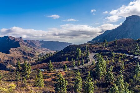 Beautifully lit dusty road horizon with monumental canyon mountains. Canary Islands.