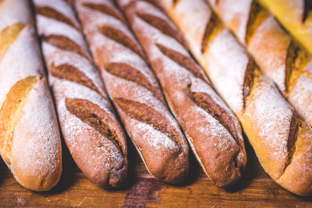 Fresh baguettes lie on a wooden table.の写真素材
