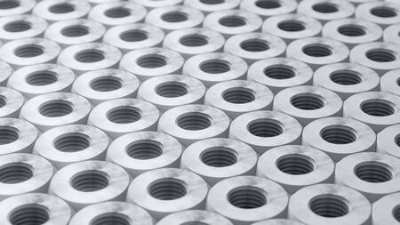 Perfectly packed grid of steel hardware nuts with neutral lighting and a shallow depth of field....