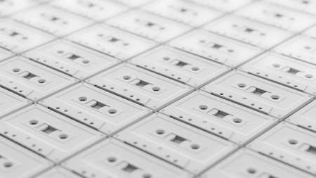 Array of untextured white music cassette tapes on a white surface. This shot features a shallow...