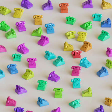 Randomly rotated retro phones in uniform vibrant colors on a slightly reflective white surface. This image is a 3d render.の写真素材