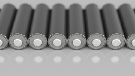 Parallel line of variously colored double-A batteries on a reflective white surface. This image is a 3d render.の写真素材