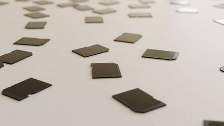 Large scattered array of black SD cards arranged on a minimally textured white concrete surface. This image is a 3d rendering.の写真素材