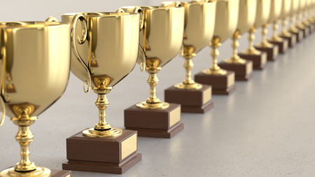Linear Array of Gold Trophys on a Light Gray Surfaceの写真素材