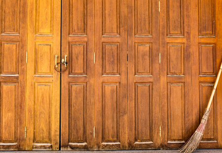locked yellow door with old broomの写真素材