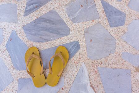 The yellow sandals on rock floorの写真素材