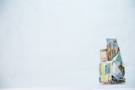 Local currencies and Naira notes in a glass jar - concept of Savingの写真素材