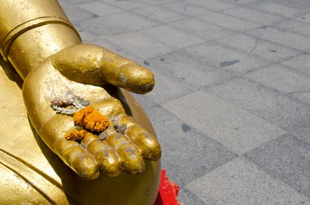 Coins on hand Buddhaの写真素材