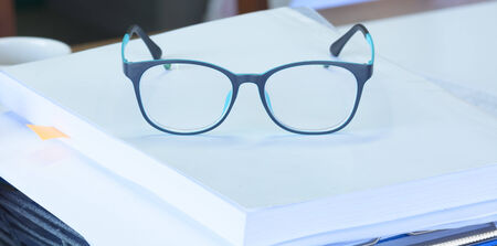 Blue  eye  glass on top  of  bookの写真素材