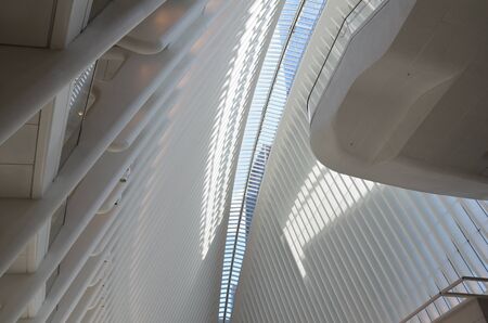 bright white building interior with tall ceiling and windowsの写真素材