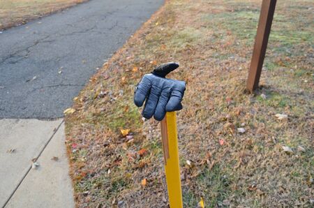 black glove on yellow wood stake or pole