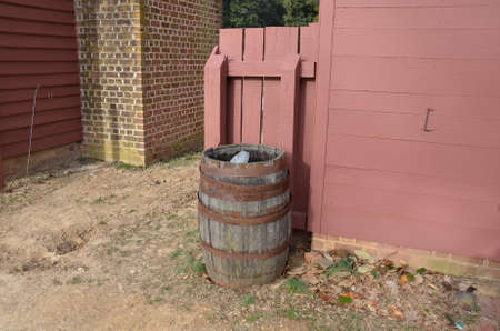 wood barrel with metal rings and red bricks and red wall on building