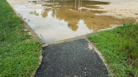 path to sand in volleyball court with water puddleの写真素材