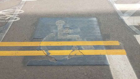 wheelchair sign with yellow lines painted over